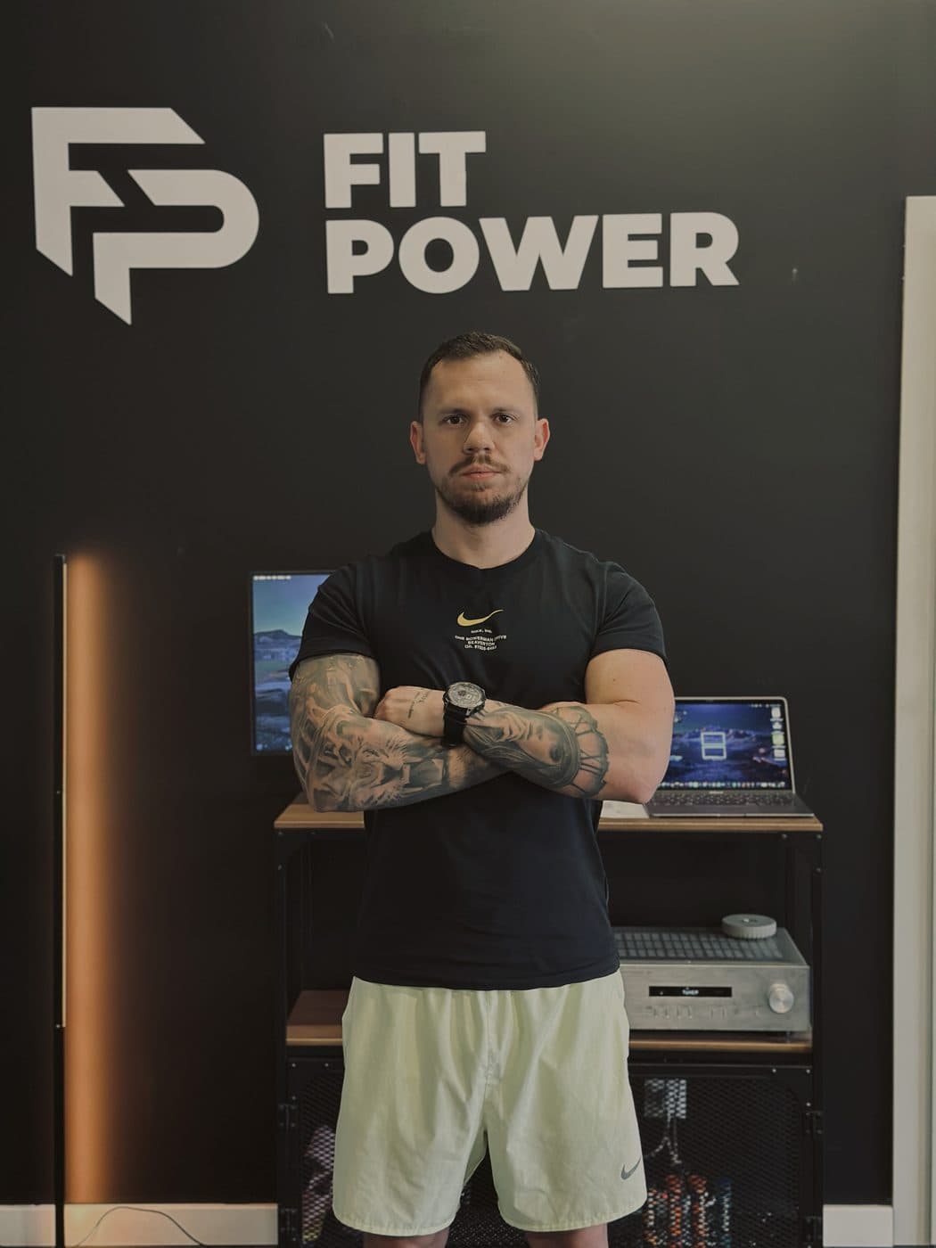 Przemysław Synoradzki w studiu FitPower, przy ścianie z logo